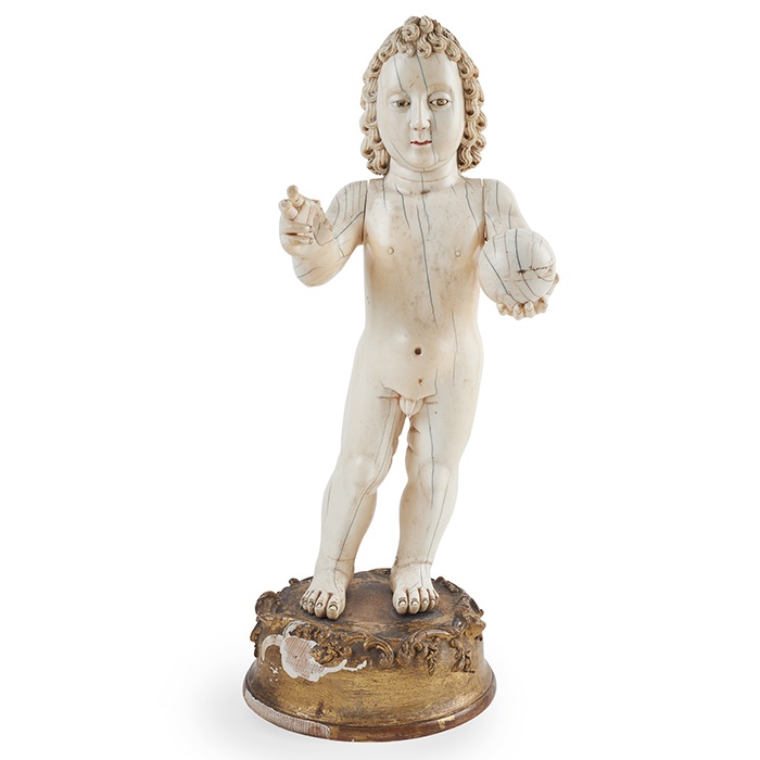 LOT 429 | Y LARGE INDO-PORTUGUESE CARVED IVORY FIGURE OF THE INFANT CHRIST AS SALVATOR MUNDI, THE SAVIOUR OF THE WORLD | LATE 17TH/ EARLY 18TH CENTURY, GOA the child Christ standing with both arms extending, one holding an orb to represent the world in his left hand, his right hand raised in blessing, on a giltwood and gesso base Figure 42cm high; 49cm high overall | £8,000 - £12,000 + fees