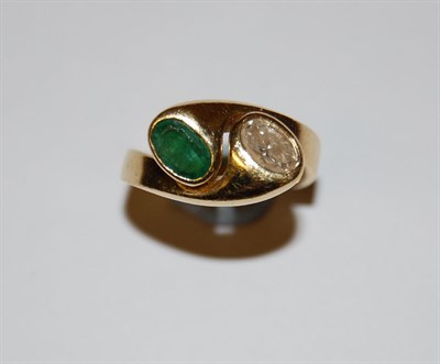 Lot 20 - An emerald and diamond set two-stone ring