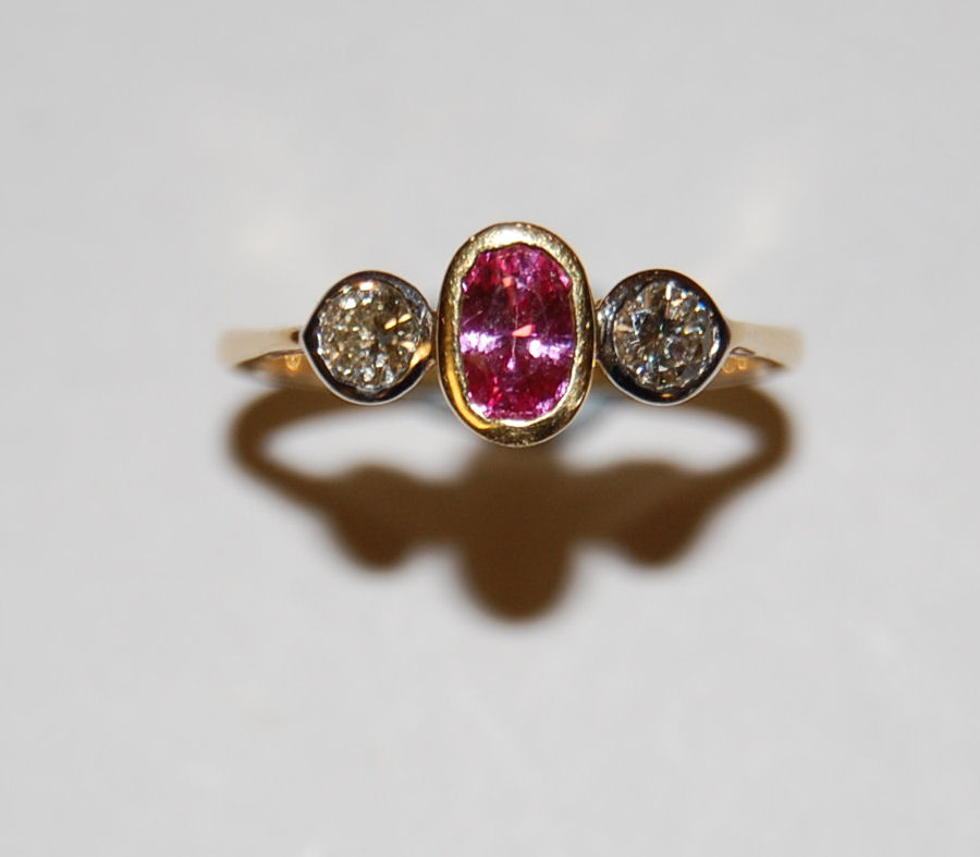 Lot 193 - A three stone pink sapphire and diamond ring
