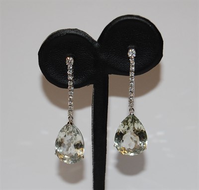 Lot 134 - A pair of diamond and pale green quartz pendant earrings