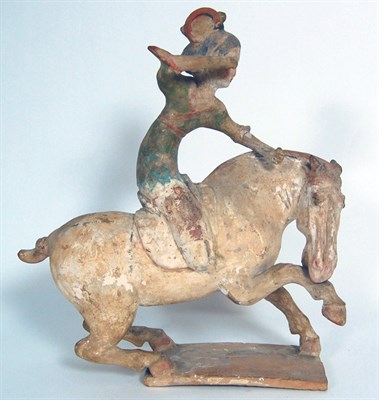 Lot 27 - CHINESE EARTHENWARE PAINTED FIGURE OF A FEMALE POLO PLAYER MOUNTED ON A REARING HORSE