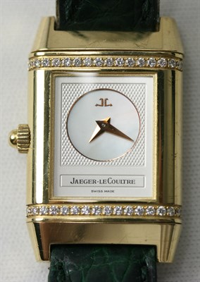 Lot 115 - JAEGER-LE COULTRE - a lady's 18ct gold diamond set Reverso wrist watch