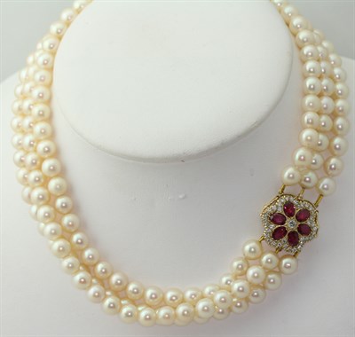Lot 193 - A cultured pearl three-row necklace with ruby and diamond set clasp