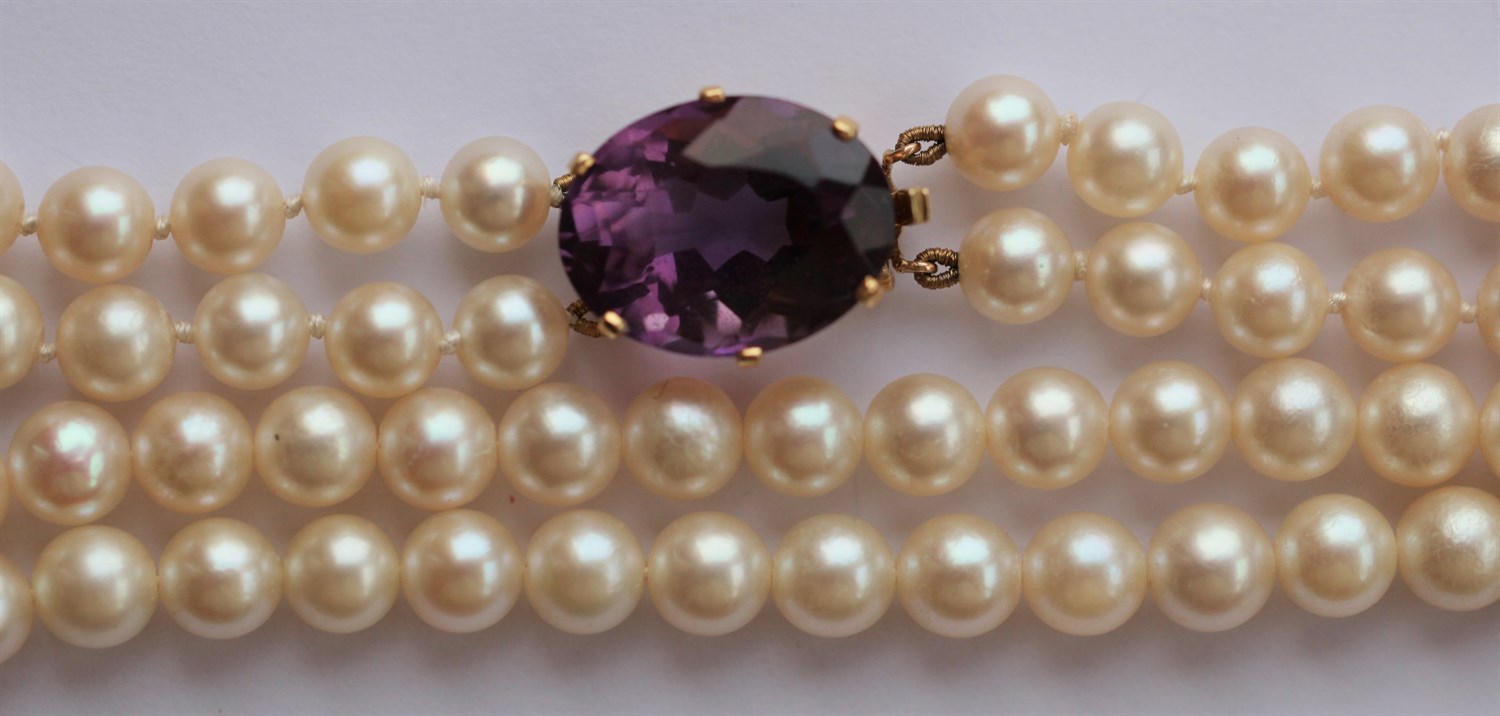 Lot 265 - A two-row cultured pearl necklace with amethyst set clasp