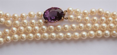 Lot 265 - A two-row cultured pearl necklace with amethyst set clasp