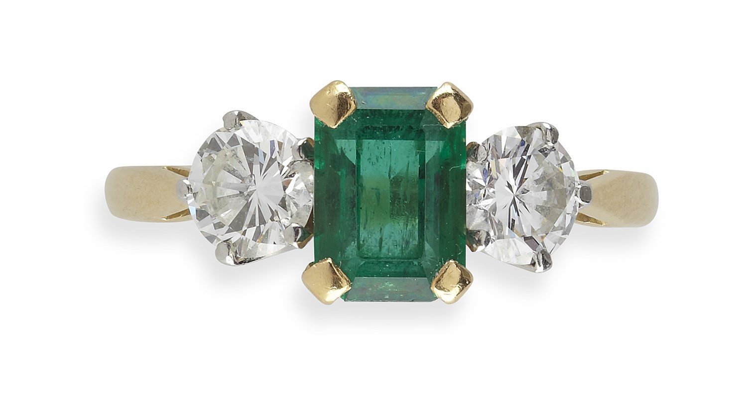 Lot 230 - An 18ct gold mounted emerald and diamond set three-stone ring