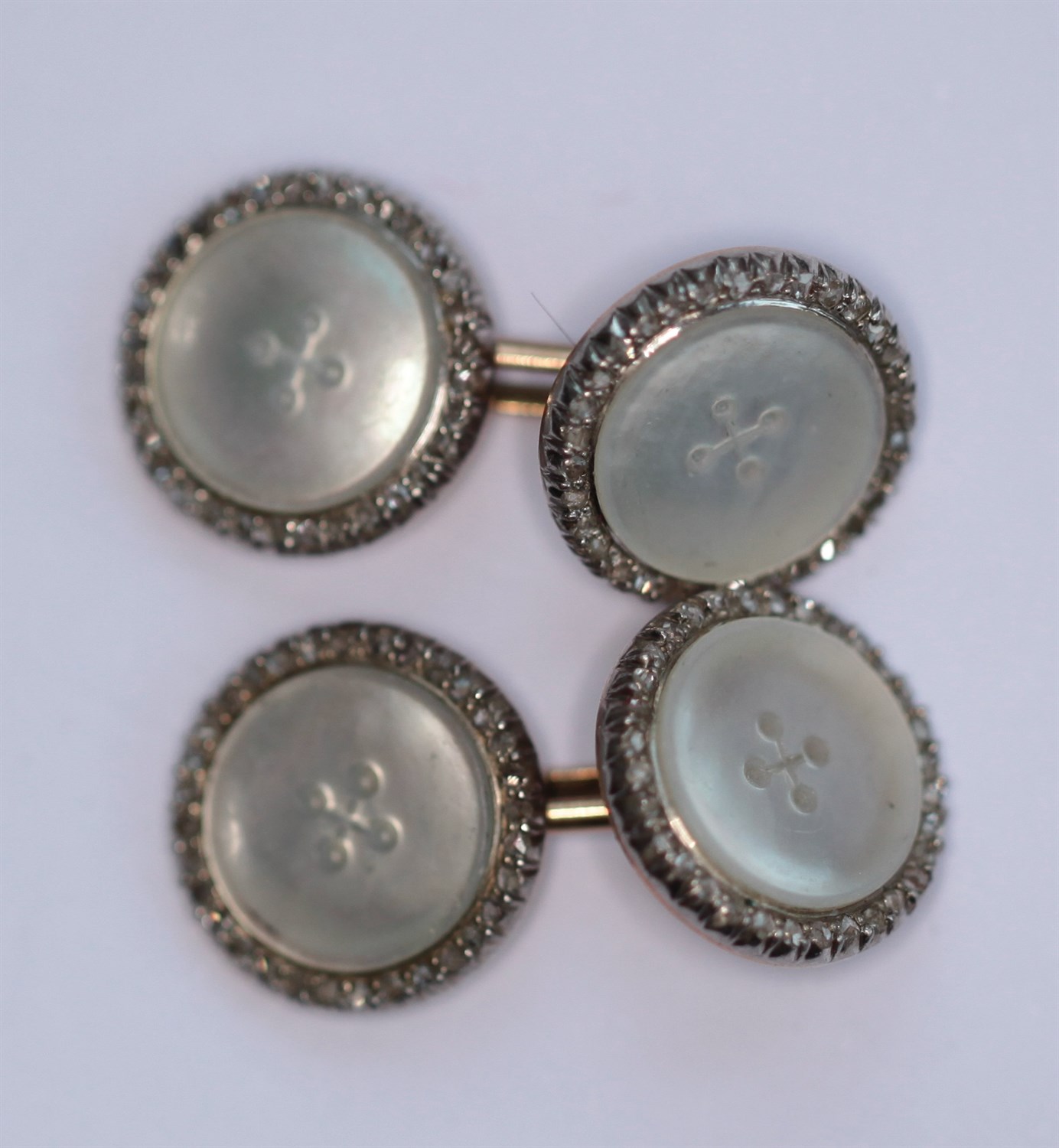Lot 86 - A pair of early 20th century mother-of-pearl and diamond set cufflinks