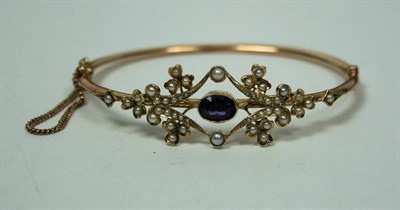 Lot 418 - An Edwardian amethyst and seed pearl bangle