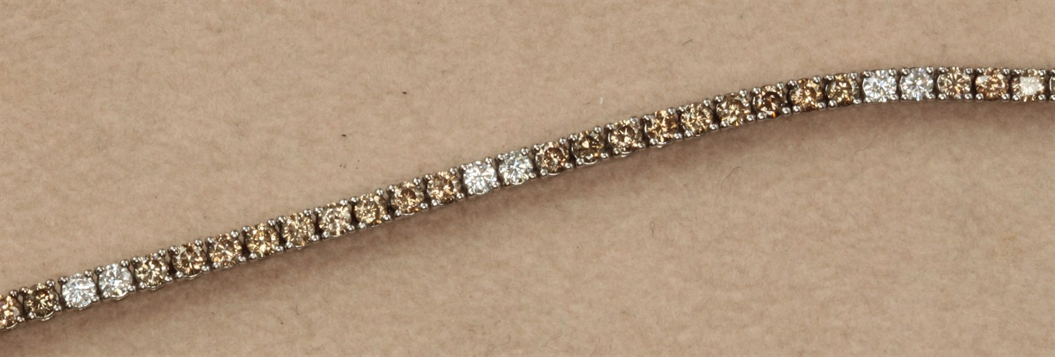 Lot 214 - A fancy brown and colourless diamond set line bracelet