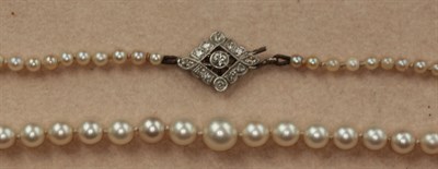 Lot 320 - An early 20th century cultured pearl necklace with diamond set clasp