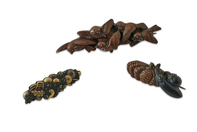 Lot 12 - A group of three Japanese bronze and gilt menuki as brooches
