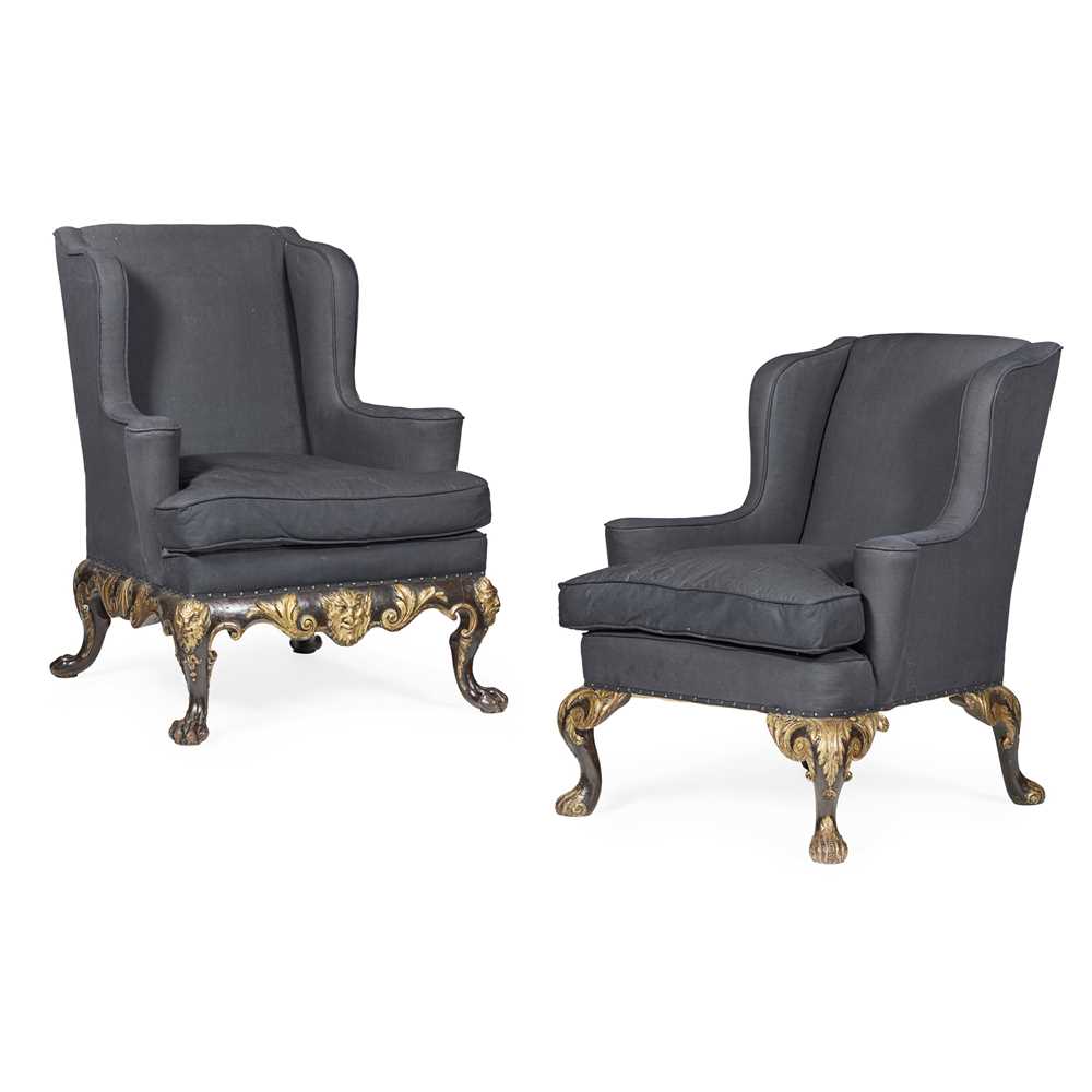 Lot 22 - TWO GEORGE II STYLE EBONISED MAHOGANY AND PARCEL GILT WING ARMCHAIRS