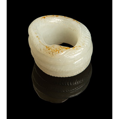 Lot 116 - WHITE JADE WITH RUSSET SKIN 'SERPENT' THUMB RING